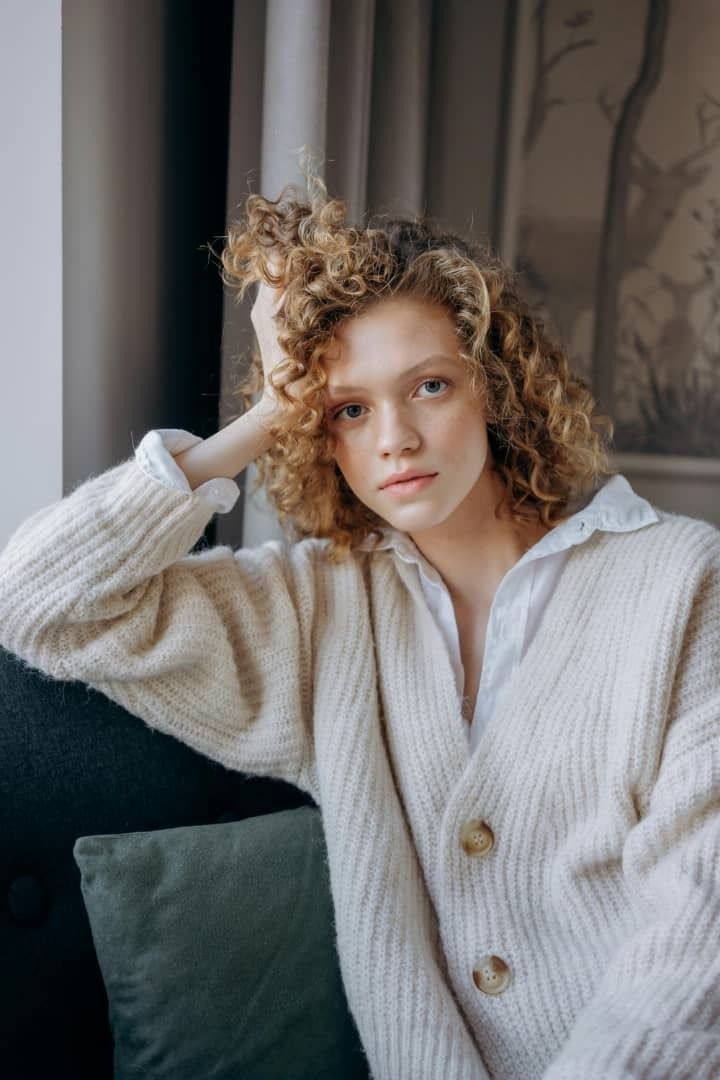 In-house portrait of Selene Quinn shot against a charcoal studio backdrop with soft pink rim lighting for editorial bios.